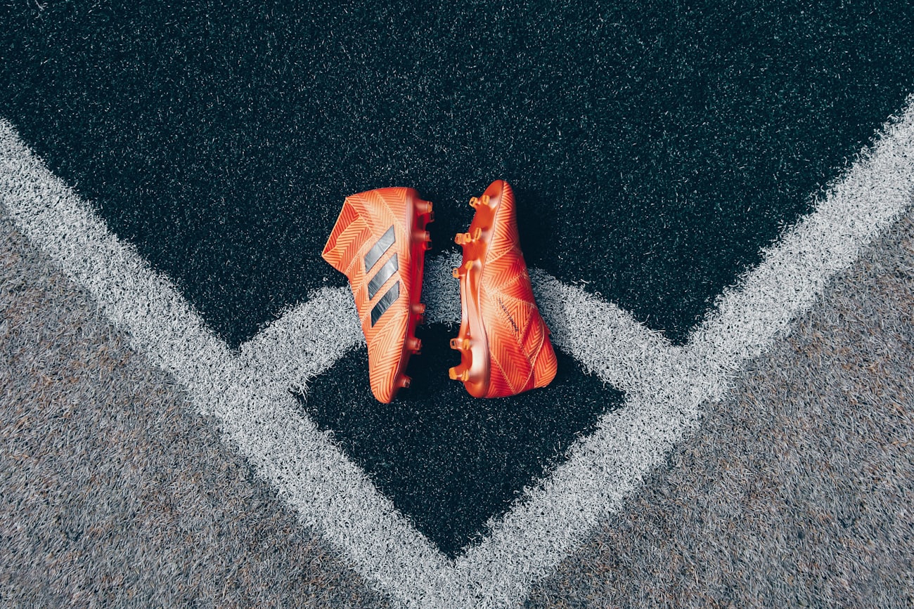 Soccer cleats resting on the pitch markings