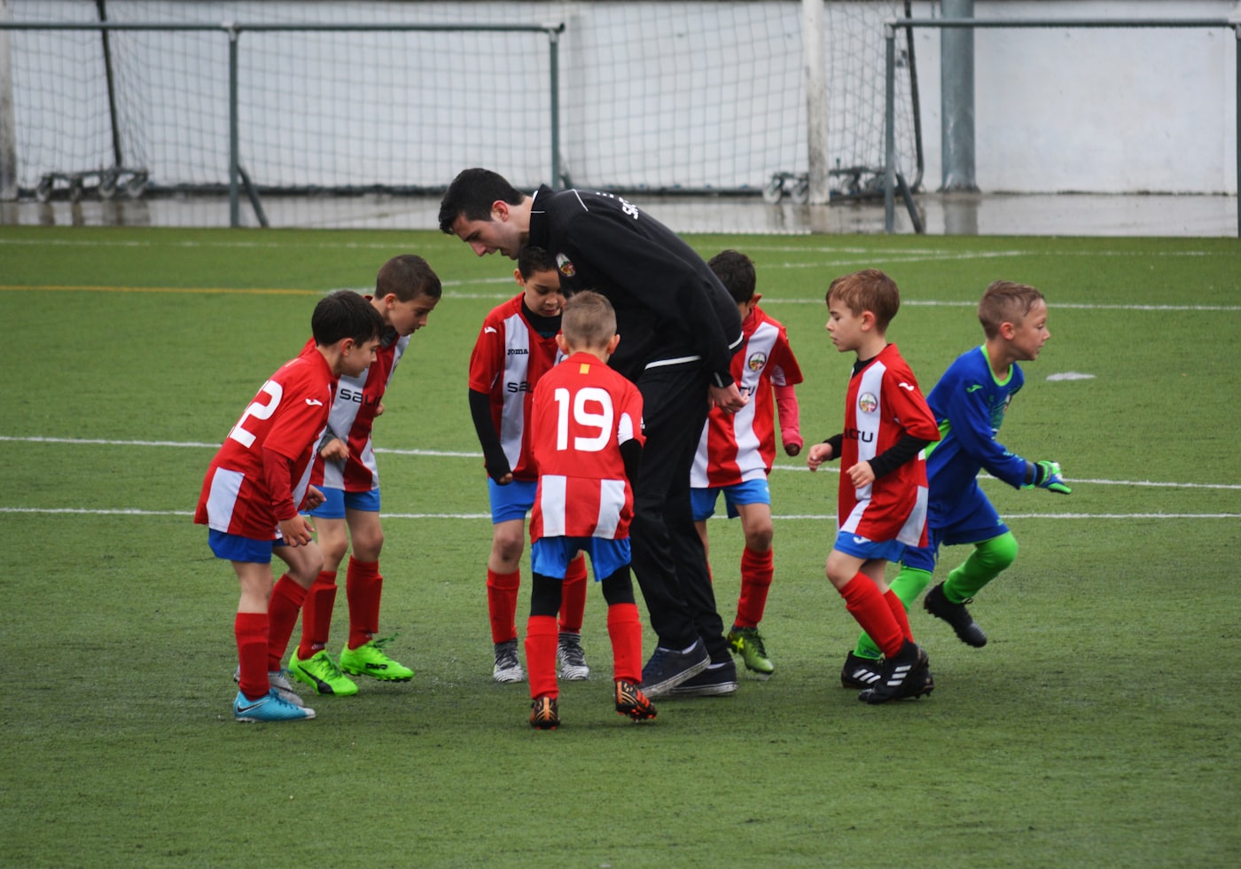 Coach guiding young soccer players on the field